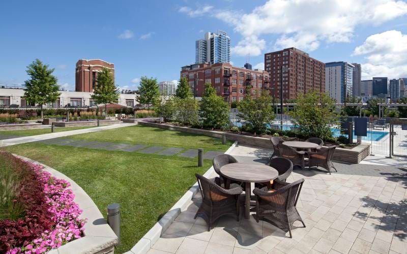 a patio with a table and chairs and a large city landscape