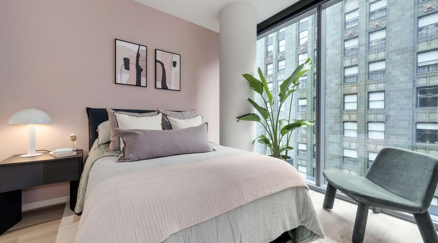 Bedroom with a bed and a large window and table with lamp