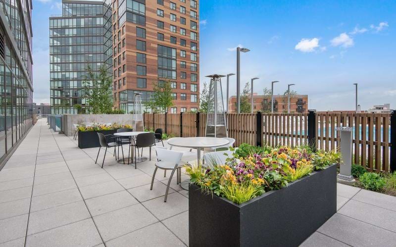 a patio with tables and chairs and flowers on it