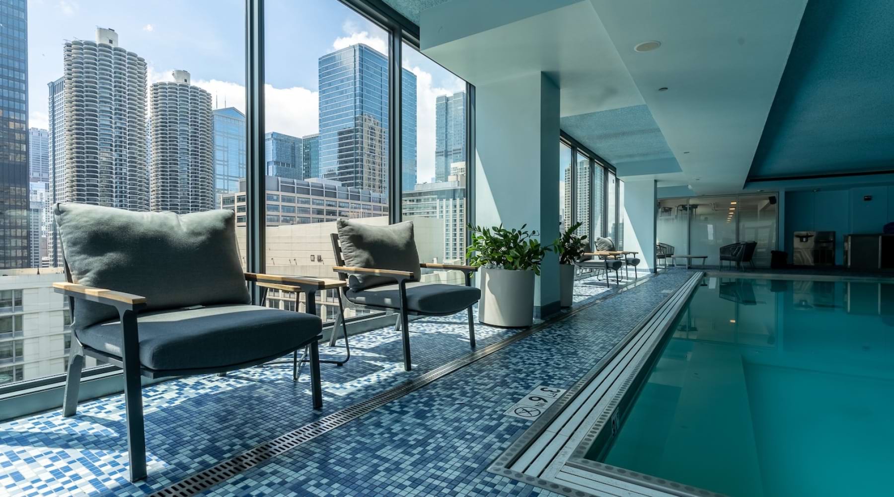 Indoor pool with lounging areas at  State and Grand Apartments for rent in Chicago.