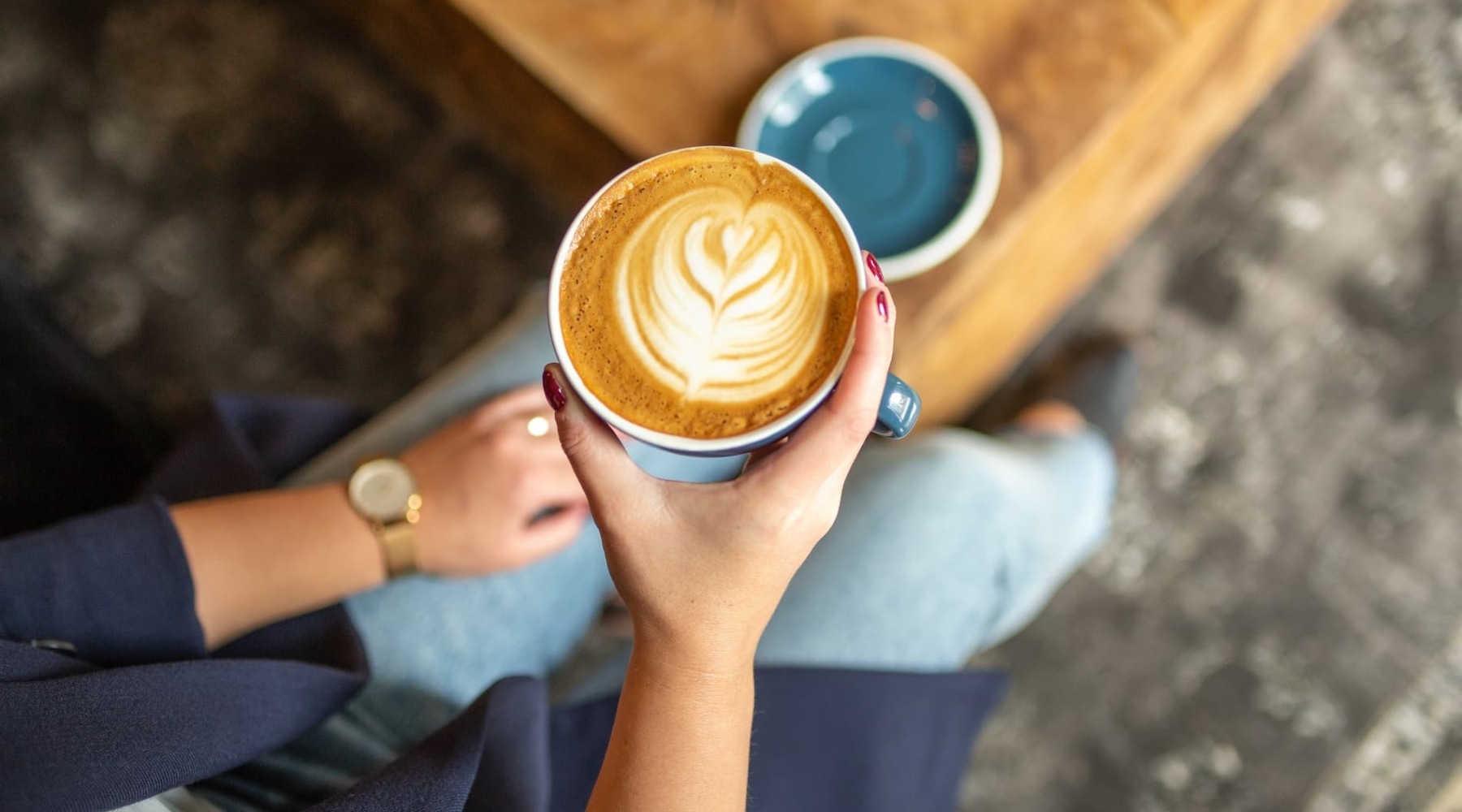 a woman's hands holding coffee indoors