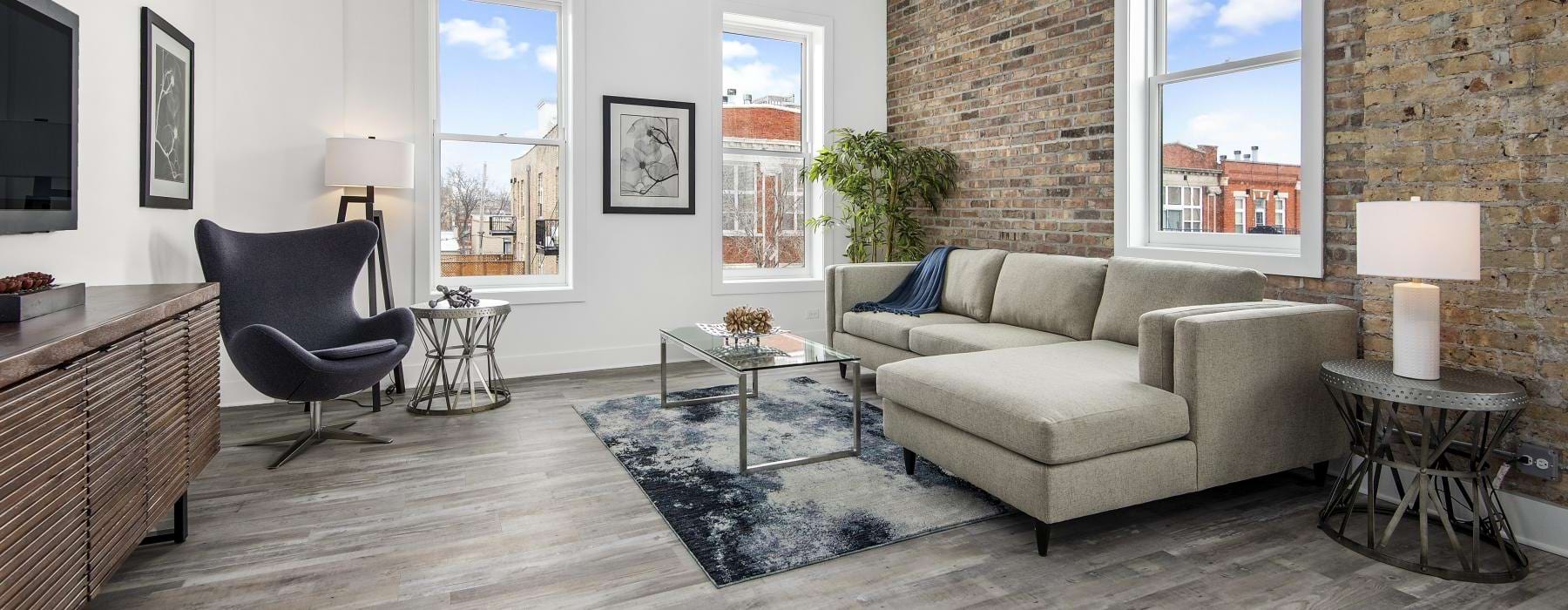 a living room with a stone wall and natural lighting from surrounding windows