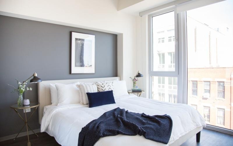 bedroom with massive windows offering city views