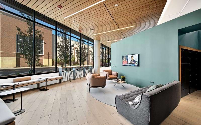a clubhouse room with chairs, tables and a large window