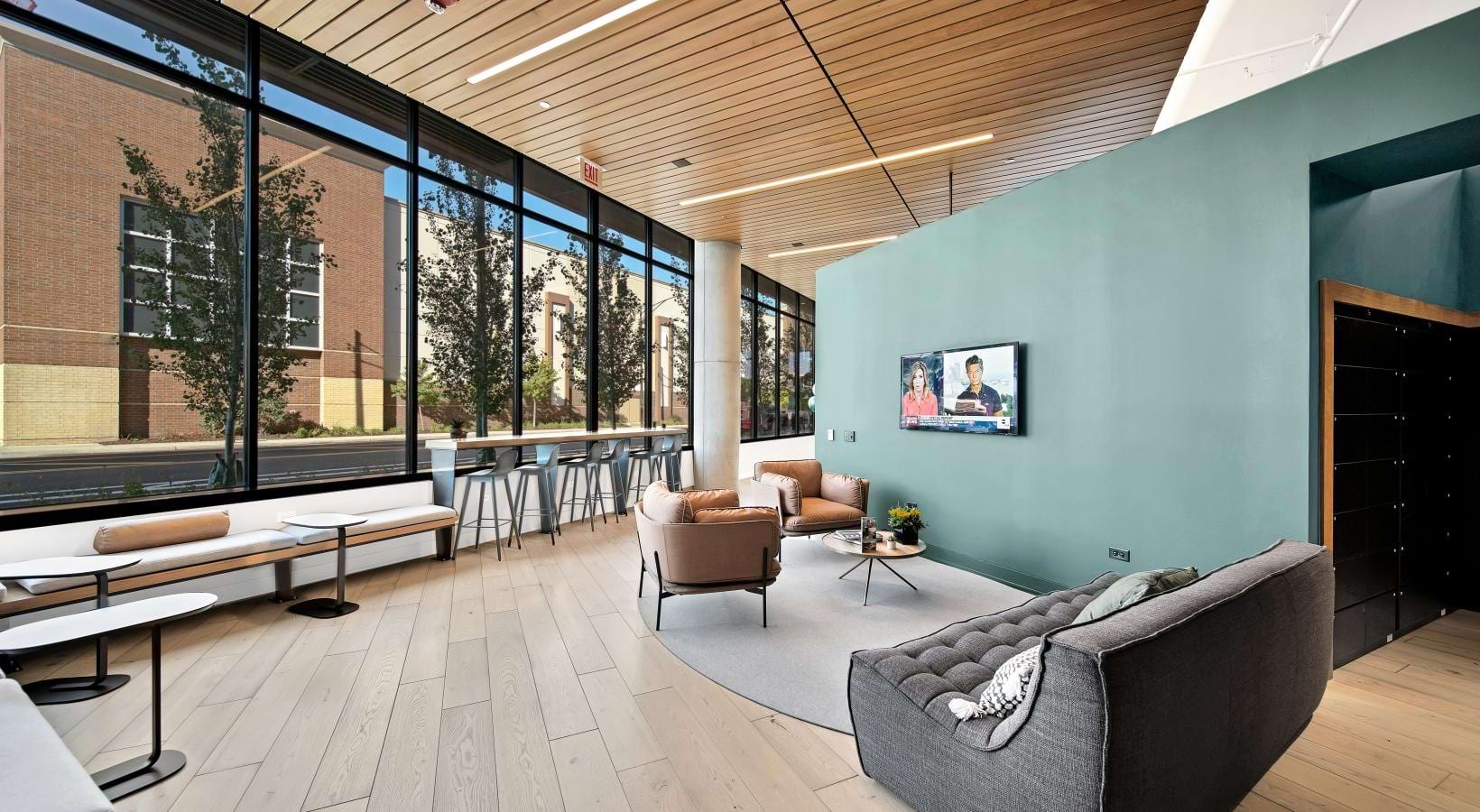 a clubhouse room with chairs, tables and a large window