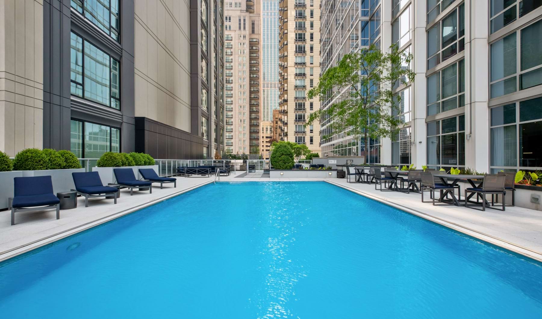 Outdoor pool with sitting area and grill space
