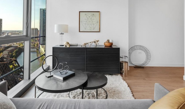 a living room with a large window and views of the city